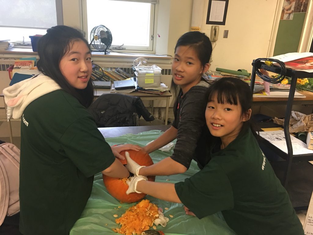 Newcomer students carve pumpkins with CultureLink's Monday Club